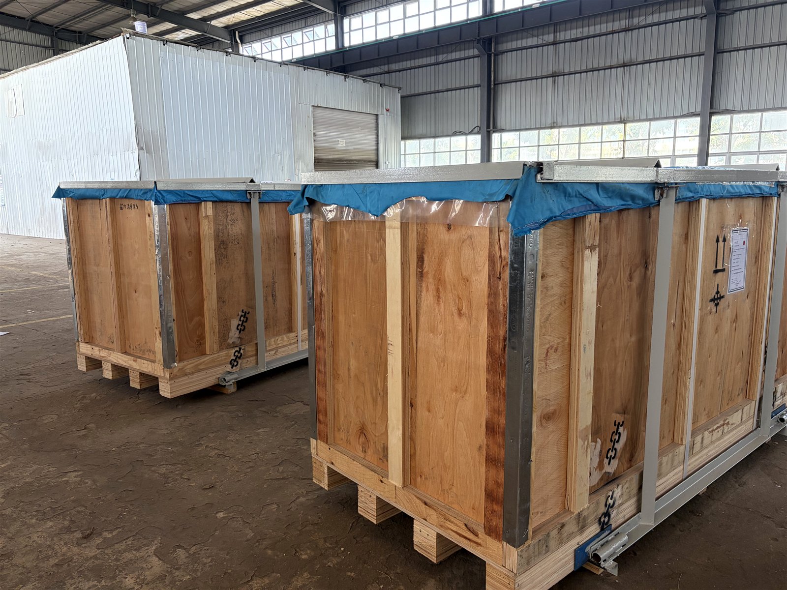 Plywood export crates with steel edge protection and moisture barrier awaiting container loading