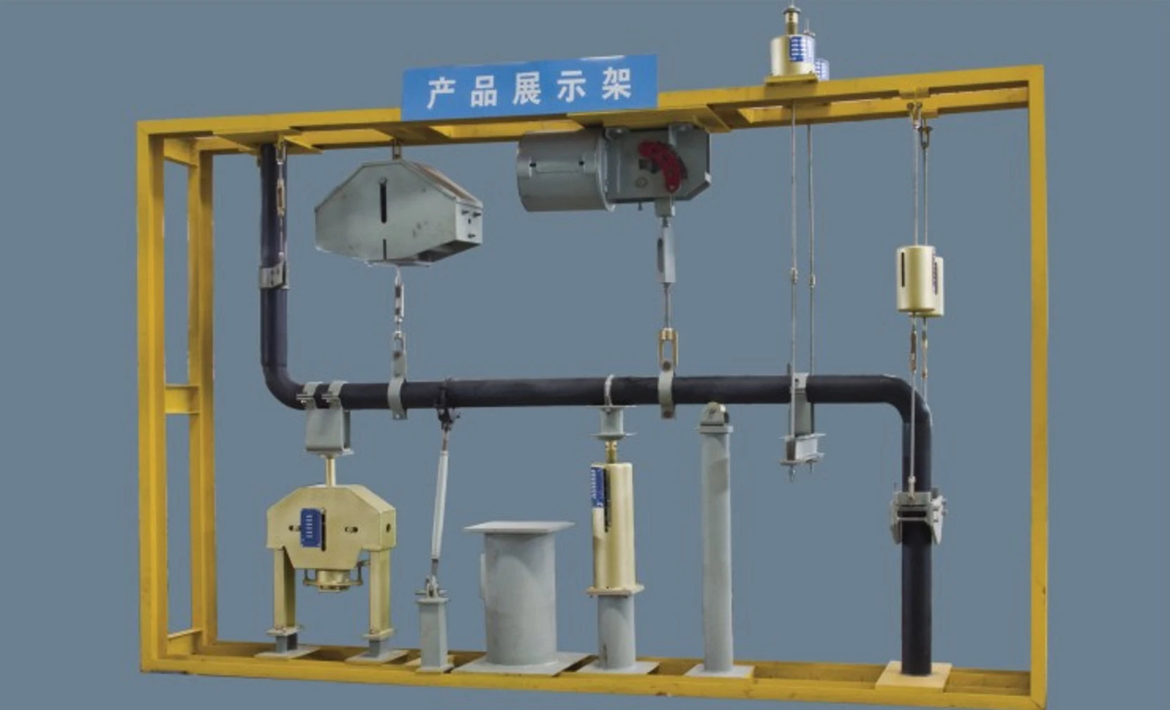 Factory demonstration rack showing the full pipe support range: constant hangers, variable spring supports, rigid hangers, sway braces, riser clamps and sliding supports mounted on a demo pipe run