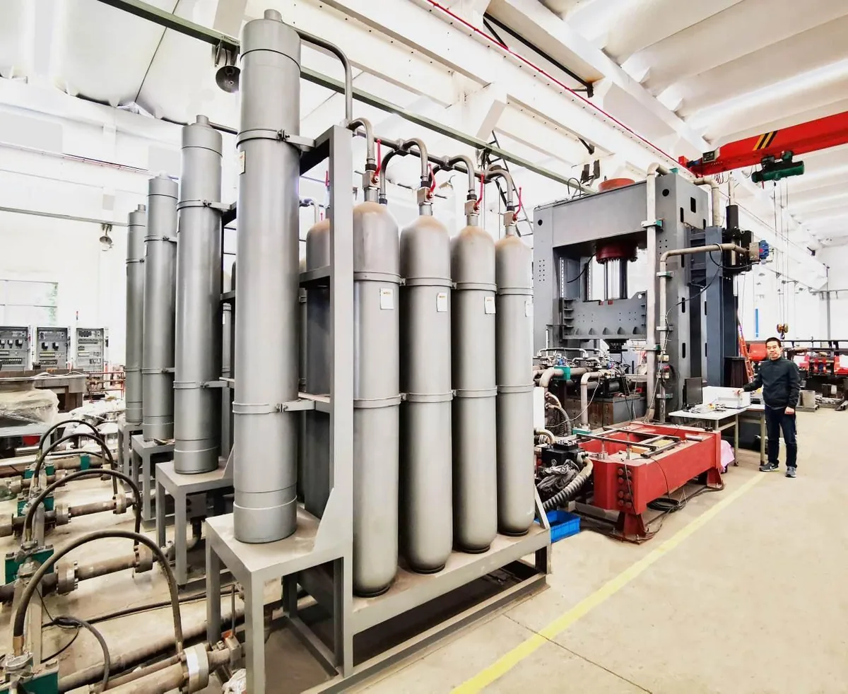 Factory testing area with hydraulic cylinders and large test equipment